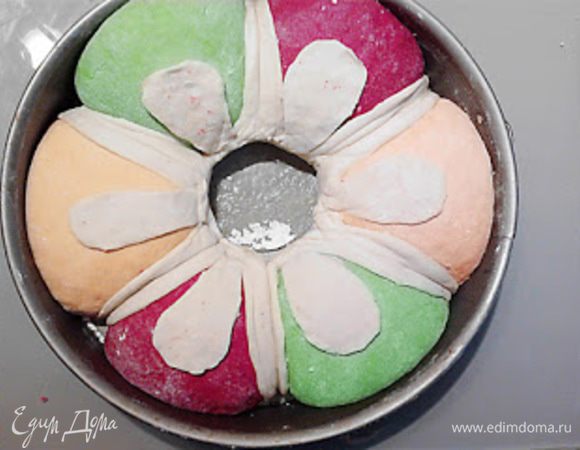 Аккуратно разрезаем белое тесто и расправляя его закрываем швы между колобками. Убираем стакан.