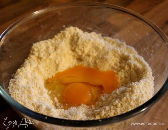 Добавить в крошку желтки, быстро замесить тесто и скатать его в шар. Накрыть тесто пищевой плёнкой и убрать в холодильник минимум на час.