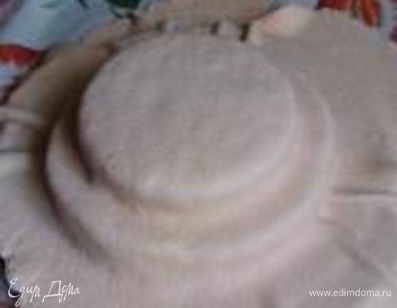 Хорошенько присыпать столешницу сахарной пудрой по всему периметру и раскатывать мастику до такого размера, чтобы гарантированно накрыть весь наш торт. Лучше раскатать посильнее, потому что потом уже нельзя будет исправить. Накрыть торт мастикой. Осторожно прижать ее ко всем поверхностям торта, повторяя его форму. Обрезать лишние края, оставляя пару сантиметров на подгиб. Подворачивать удобно при помощи 2-х лопаток:  одну помещаем под торт и, приподнимая его, аккуратно подталкиваем второй лопаткой край мастики вовнутрь.