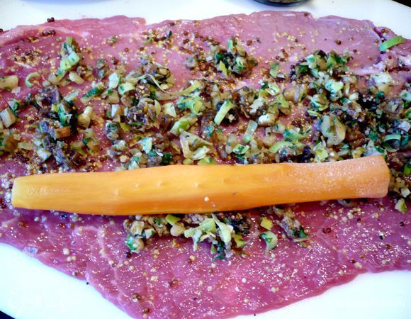 На нижнюю третью часть кусочка выкладываем морковь, так чтобы она располагалась посередине вдоль волокон.