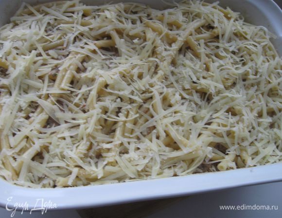 Верхний слой – макароны надо смазать взбитым яйцом и посыпать тертым на крупной терке сыром. Поставить в  разогретую до 180 градусов духовку и запекать до появления румяной корочки. 
