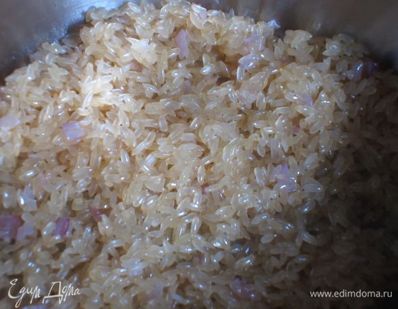 Всыпать рис и прогреть, постоянно помешивая, в течение нескольких минут, пока зерна не станут прозрачными.Влить вино. После того, как вино  выпарится, по одному половнику добавлять бульон, время от времени помешивая ризотто. Готовить около 10 минут.