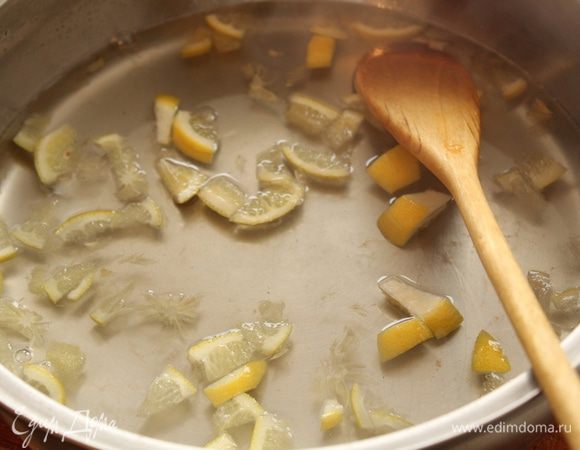 В кастрюлю налить воды, нагреть, растворить сахар. Лимон разрезать на 4 части вдоль и затем  лучше будет нарезать мелкими кубиками.