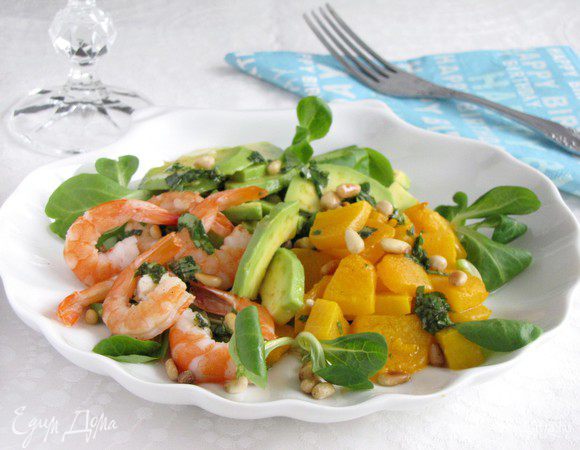 На салат выложите кучками тыкву, авокадо, креветки. Полейте заправкой, посыпьте кедровыми орешками.