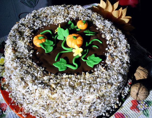 На средину торта выкладываем застывший шоколадный диск. Сверху выкладываем тыковки, цветочки и листву, формируя кустик. Оставшееся пространство засыпаем посыпкой. Отправляем торт на несколько часов в холодильник. Приятного аппетита!
