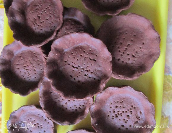 Раскатать тесто, вырезать круги и поместить их в смазанные маслом формочки. Тесто в формах несколько раз проколоть вилкой и убрать в холодильник на 20 минут. Выпекать в заранее разогретой до 200 градусов духовке 8-10 минут. 