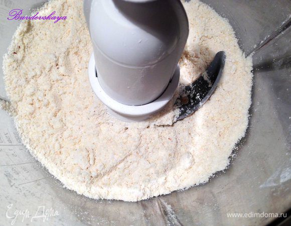 Приготовим Фундучный дакуаз. Для этого нужно крупно размолоть в комбайне половину орехов, чтобы остались небольшие кусочки. Отложить в сторону. Вторую половину фундука смешать с сахарной пудрой и размолоть на этот раз очень мелко - в пудру.