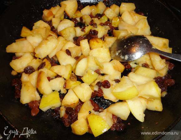 В сковороде разогреть сливочное масло и, помешивая, обжарить на сильном огне яблоки вместе с изюмом в течении 3-4 минут.