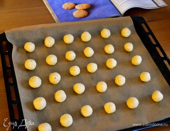 Зато из нее очень просто сформировать маленькие шарики размером с небольшой орешек. При необходимости руки можно смачивать немного в воде... Выложить полученные шарики печенья на противень, застеленный пекарской бумагой.