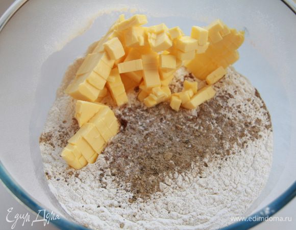 Муку просеять, добавить специи, соду, сливочное масло, порезанное кубиками.