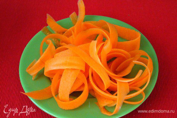 Морковь нарезаем с помощью овощечистки тонкими полосками.