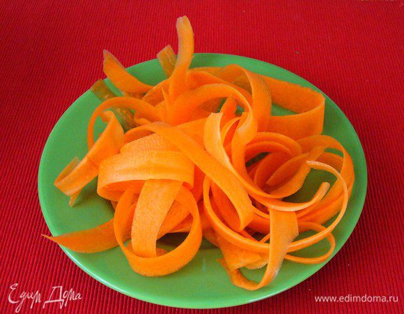 Морковь нарезаем с помощью овощечистки тонкими полосками.