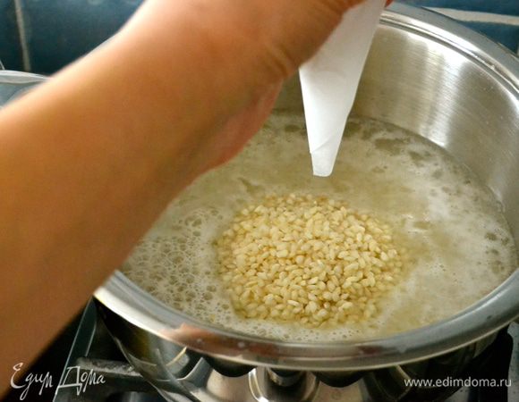 Пока обжаривается тыква, займемся приготовлением риса. В кастрюлю с толстым дном налить 600 мл воды. Как только вода начнет закипать, посолить и начать сыпать в кастрюлю рис через воронку, или попросту скрутив конус-воронку из пекарской бумаги. Держим воронку над водой и позволяем рису падать в центр кастрюли... 