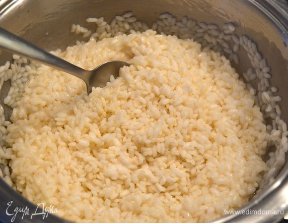 По истечении 10-12 минут снять кастрюлю с огня и перемешать рис ложкой.  