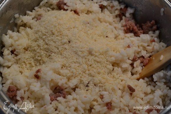 Через 10 минут открыть рис, перемешать ложкой и выложить к рису обжаренный фарш. Добавить тертый сыр. И снова перемешать. Проверить на соль и перец.