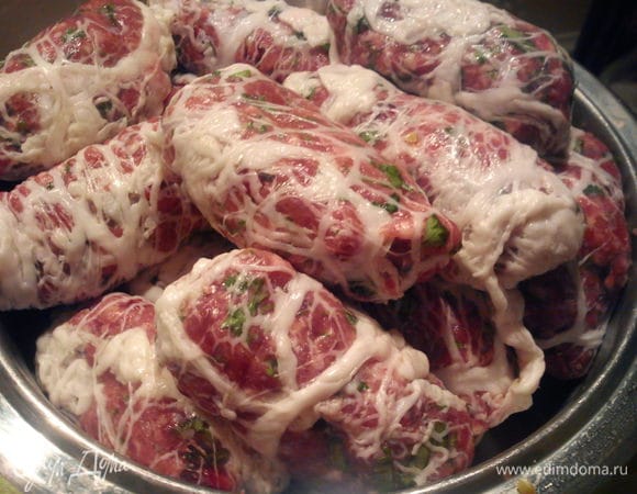 Каждый овал из фарша завернуть в жировую сетку.