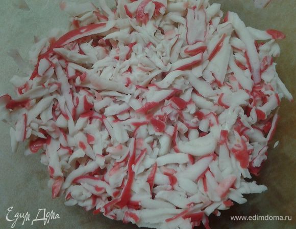 Натереть на крупной терке крабовые палочки. Смазать майонезом.