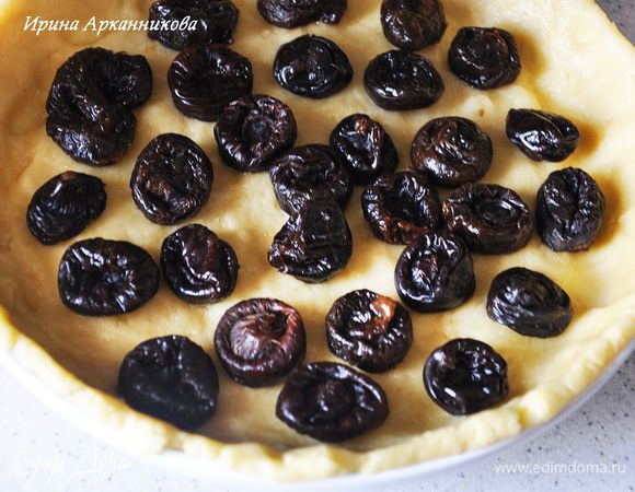 Разделить тесто на одну треть и на две трети. Большую часть руками растянуть по керамической форме (железную смазать маслом). выложить чернослив, выложить крем.