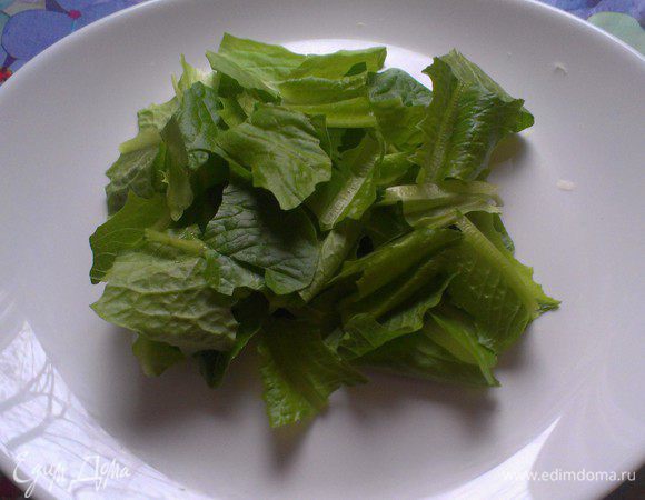 положил в нее нарезанные салатные листья "ромен" *Листья салата я аккуратно помыла, обсушила бумажным полотенцем и положила в холодильник до момента готовки. Салатные листья должны быть из холодильника – упругие и хрустящие. Чем холоднее и свежее листья, тем они хрустящее, а чем меньше воды на них остается, тем лучше заправка будет покрывать их. Я порвала салат руками.