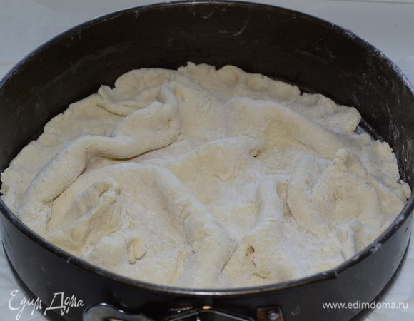 Тесто тонко раскатываем по диаметру больше примерно на 10-15 см от формы, в которой будет запекаться пирог. Выкладываем тесто в форму, формируя глубокие складки.