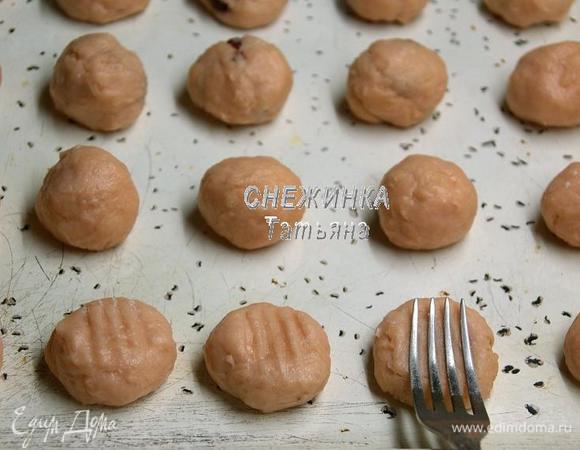 По прошествии времени, из теста катаем шарики, величиной чуть больше грецкого ореха (они уже не будут липнуть к рукам и легко приобретут нужную форму) и укладываем на противень на некотором расстоянии. Затем приплющиваем шарики, можно ладошкой, можно вилкой, чтобы получились готовые печенья более менее одинаковой формы.