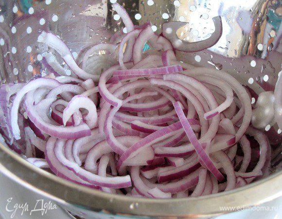 Тем временем нарезать красную луковицу тонкими полукольцами и промыть под проточной водой.