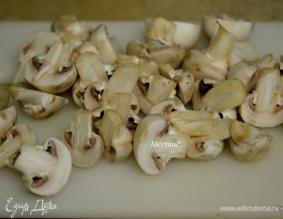 На большой сковороде обжарим порезанный лук. Добавим сухие специи. Шампиньоны порежем на пополам.
