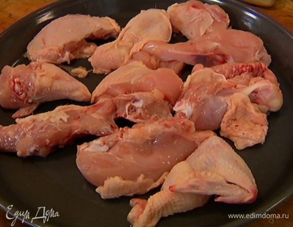 Тушку цыпленка разделать на небольшие куски и поместить в большую круглую форму для выпечки.