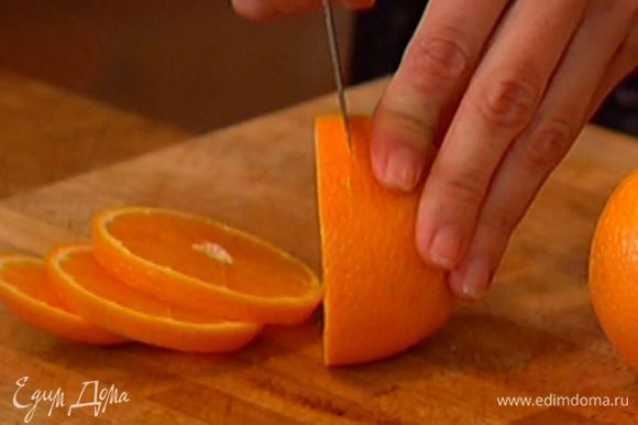 Апельсины, не очищая, нарезать толстыми кружками.