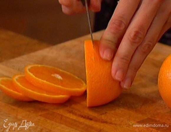Апельсины, не очищая, нарезать толстыми кружками.