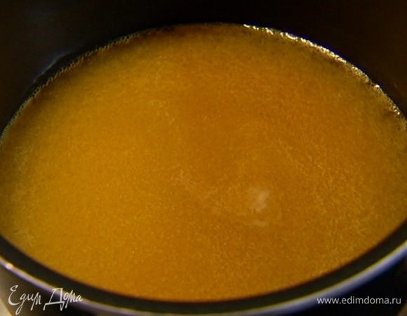 Приготовить карамель: апельсиновый сок влить в небольшую кастрюлю, добавить сахар, поместить на огонь и сварить карамель.