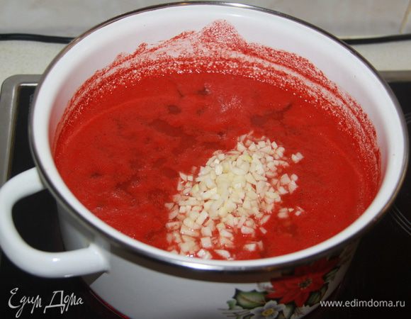 Томат поставить на огонь. Пока томат нагревается, нарезать чеснок мелким кубиком (только не через чеснокодавилку!), добавить к томату.