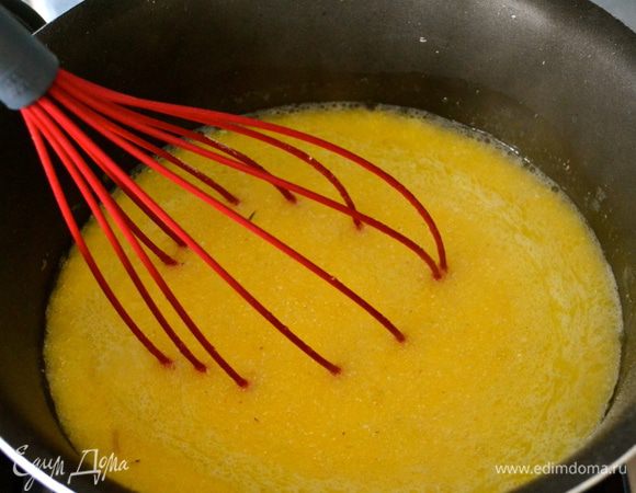 Теперь займемся приготовлением поленты! Воду, в которой мы будем варить поленту, посолить и добавить пару ложек оливкового масла. Как только начнет закипать всыпать струйкой кукурузную муку, постоянно мешая венчиком, чтобы не сформировались комки.  