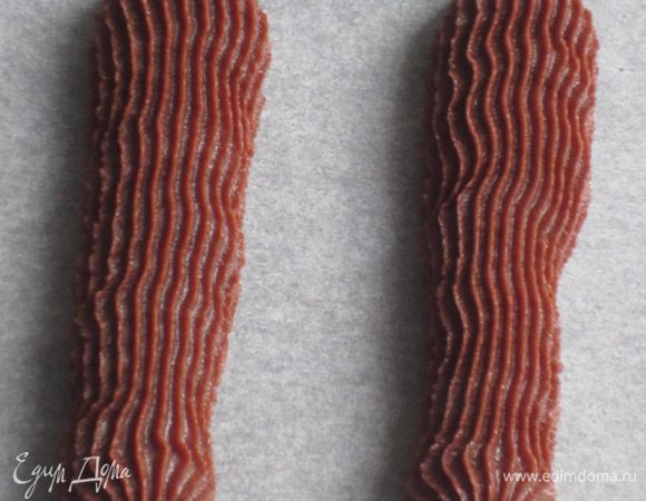 Тесто выложить в кондитерский мешок и на противень с пергаментом выдавить фигурные полоски длиной 5-6 см.Выпекать в разогретой до 180°С духовке 10-12 минут.Остудить на решётке.