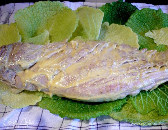 В жаровне разогреваем оливковое масло и обжариваем промытое в холодной воде, протертое бумажным полотенцем и приправленное солью и перцем мясо со всех сторон. Листья раскладываем на полотенце или доске в виде прямоугольника чуть длиннее нашего филе и примерно раза в три шире. При этом важно укладывать листья так, чтобы места прикрепления листиков к кочерыжке смотрели внутрь. Мясо смазываем горчицей со всех сторон. Кладем на нижнюю треть нашего прямоугольника и плотно заворачиваем мясо в листья капусты.