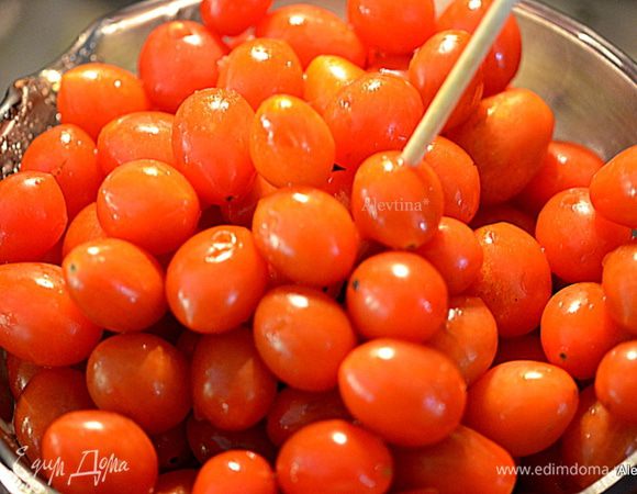 Промоем помидоры под проточной водой. Затем воду слить. Каждый томат проткнуть зубочисткой или шпажкой.