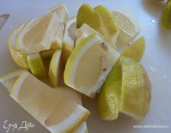 Вымыть лимоны и разрезать их пополам, а затем на ломтики пол сантиметра толщиной.
