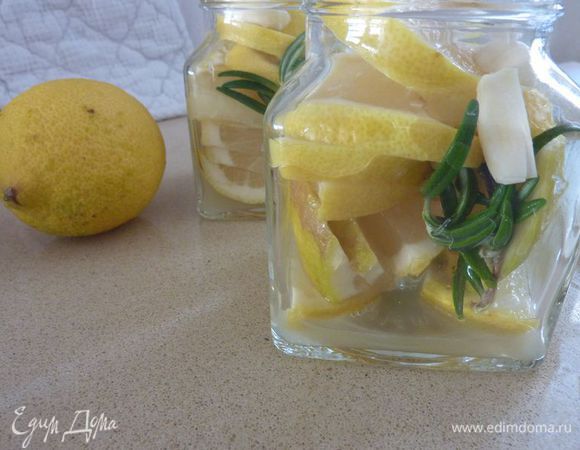 Разложить в стерилизованые банки лимоны,  розмарин и чеснок.
