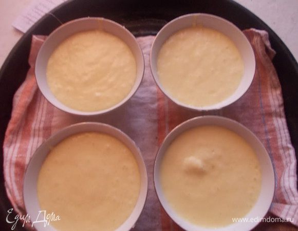 Разлить тесто по формочкам,смазанных маслом и поставить на противень с полотенцем на дне. Налить туда горячую воду,чтобы она покрывала формочки до половины. Запекать,в разогретой духовке 180С 35-40 минут.