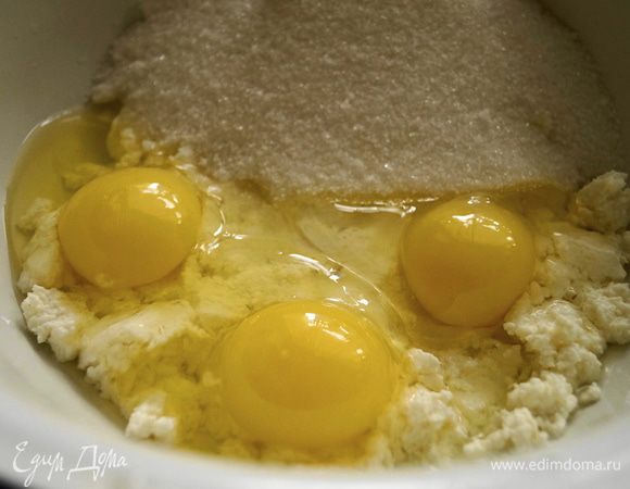 Творог растереть, добавить сахар и яйца. Все хорошо перемешать до однородной массы, так чтобы сахар растворился.