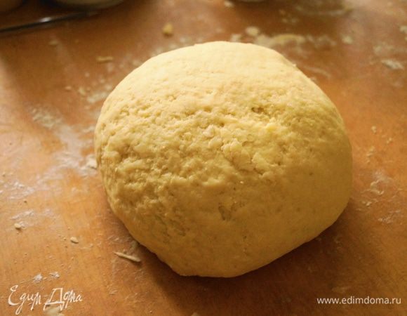 После этого к творожной массе добавить размягченное масло и соединить их. Затем добавить разрыхлитель и перемешать. Всыпать частями муку, сначала замешивая ложкой, а когда тесто станет трудно мешать, то начать месить руками до образования гладкого нежного теста.