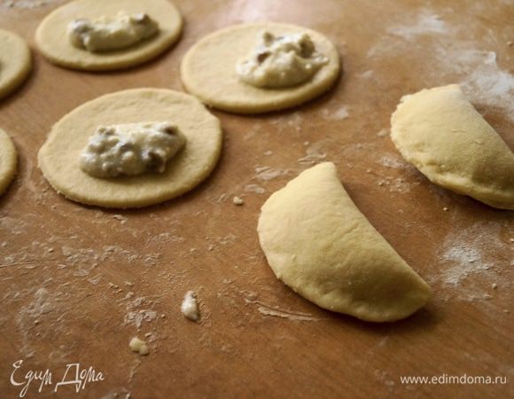 На каждый край кружочка положить понемногу творожной начинки. Накрыть вторым и защипать края.