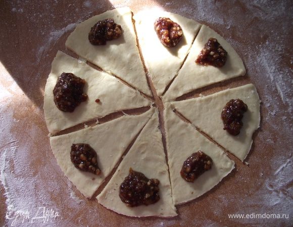 На присыпанном мукой столе раскатать тесто  толщиной 3-5 мм. 
Разрезать на треугольники. 
Выложить начинку и свернуть от широкого края к узкому.