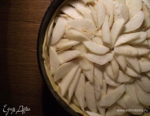 Нарезаем тонкими ломтиками и выкладываем плотными слоями на корж. Каждый слой посыпаем сахаром.