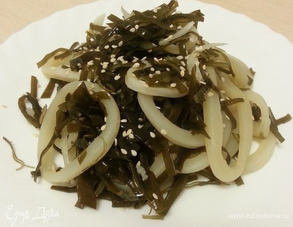 Чаще всего я использую такую капусту для всевозможных салатов. Например, такой: кальмара нарезаю кольцами, отвариваю в воде в течение 3 минут, сливаю воду, добавляю измельченный чеснок и лимонный сок, оставляю мариноваться. Лук нарезаю полукольцами, смешиваю с морской капустой, добавляю к кальмарам, заправляю соевым соусом и оливковым маслом, посыпаю кунжутом.