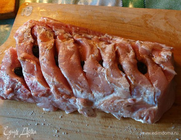 Очистить чеснок и раздавить ножом. Разрезы в мясе поперчить. В каждый из них вложить чеснок, как можно глубже, сверху положить (в каждое отверстие) маслины. 