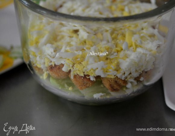 Выложить слоями сначала салатные листья, затем готовое и мелко порезанное куриное мясо, яйца сваренные вкрутую на крупной терке.
