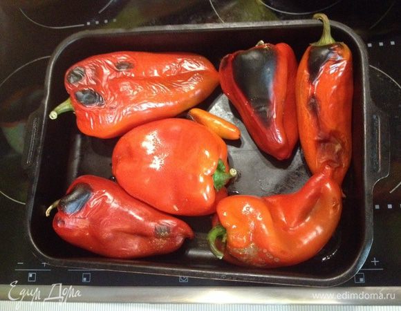 Перцы выложить в противень и поставить в духовку обжариваться. Температура 200 градусов. Переворачивать по степени обжарки. 