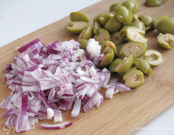 Оливки разрезать пополам, лук мелко порубить.