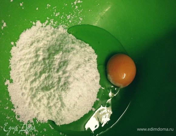 В миску разбить яйцо и всыпать стакан сахарной пудры...